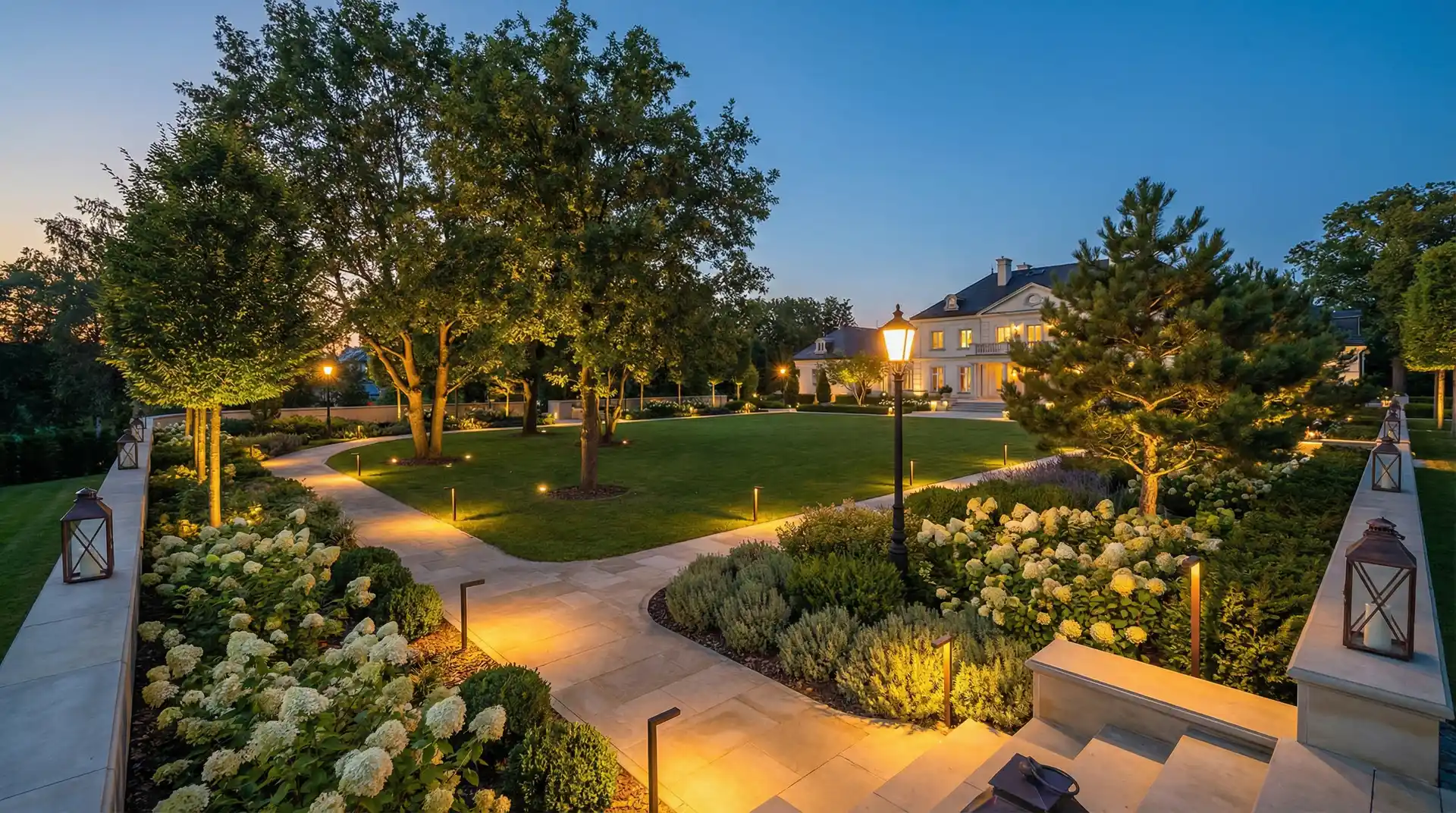 Profesjonalne oświetlenie ogrodowe w poznańskim ogrodzie o zmierzchu — ścieżki podświetlone lampami LED i podświetlone drzewa